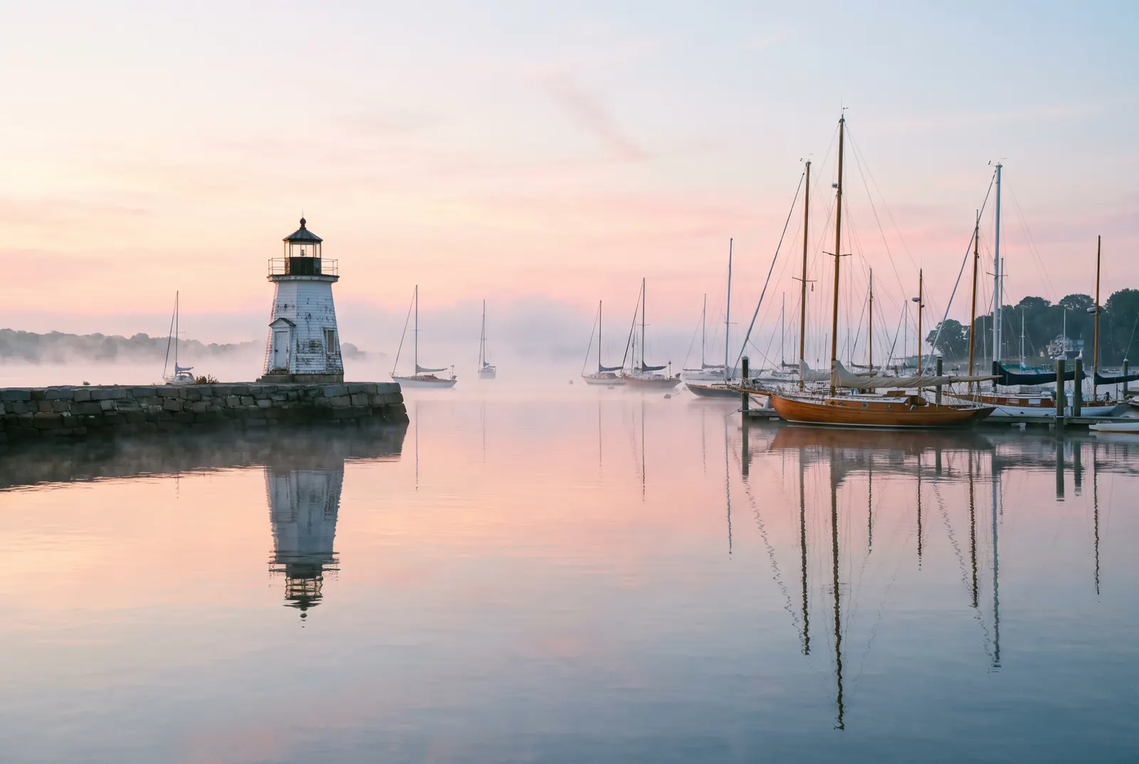 Calm Connecticut harbor with a small lighthouse at sunrise