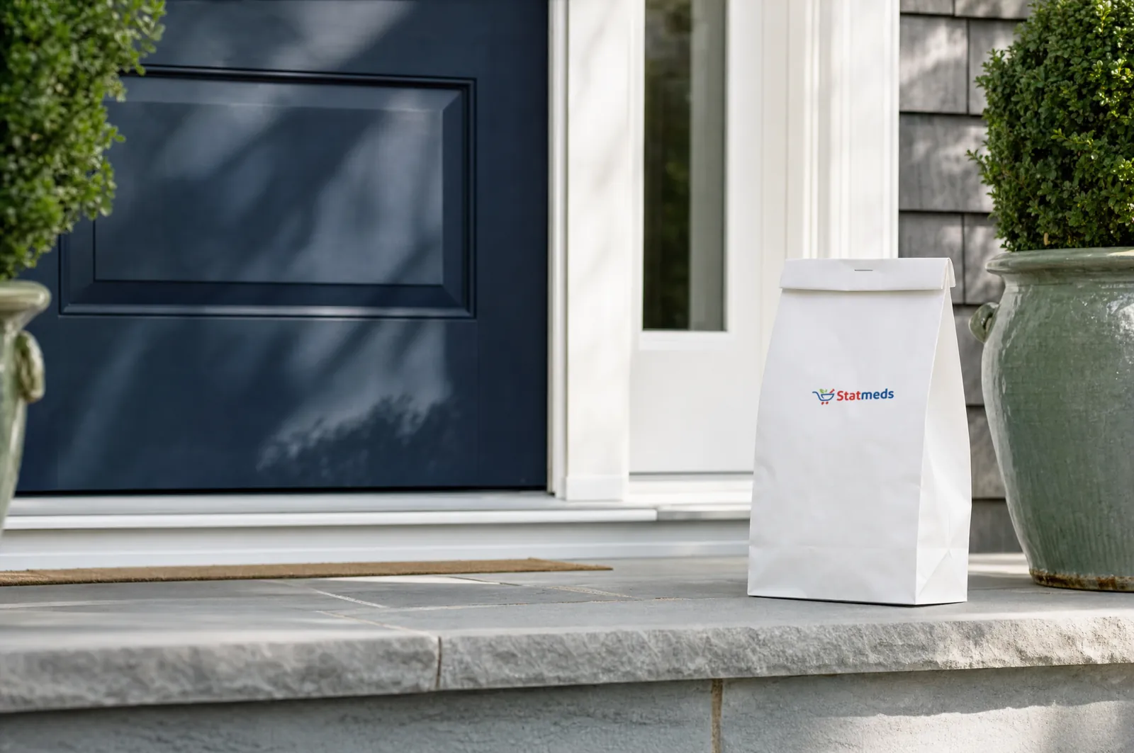 Sealed pharmacy bag on the front step of a colonial home beside a navy door